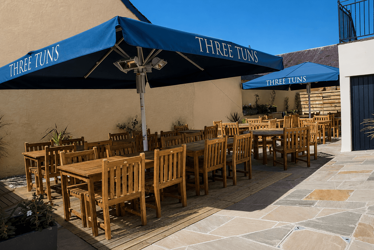 Outside area in the three tuns. Outside wooden tables and chairs